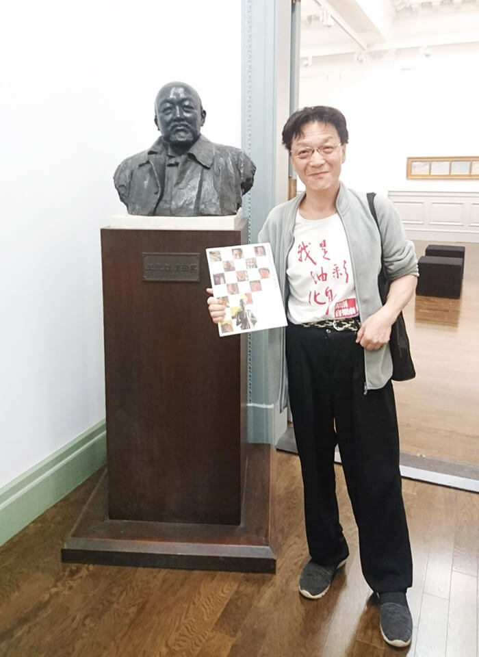 洪國雄老師遠赴日本尋根藝術，與日本畫家黑田清輝雕像合照。