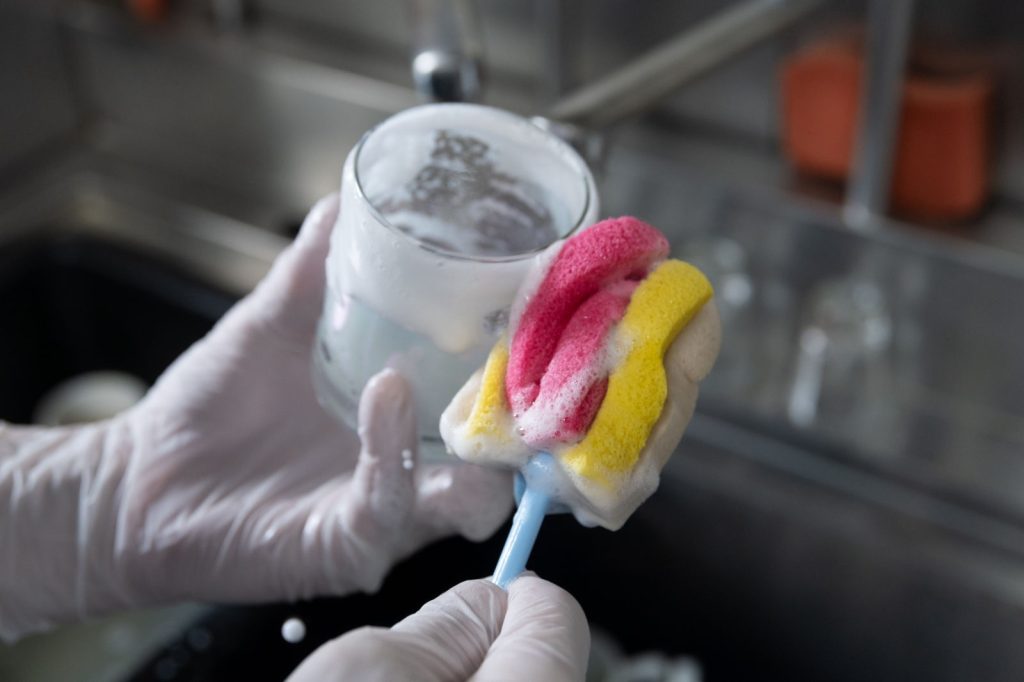 為降低飲料杯破損，黃偉桐手工特製一款底部有軟墊的刷具，專洗飲料杯。